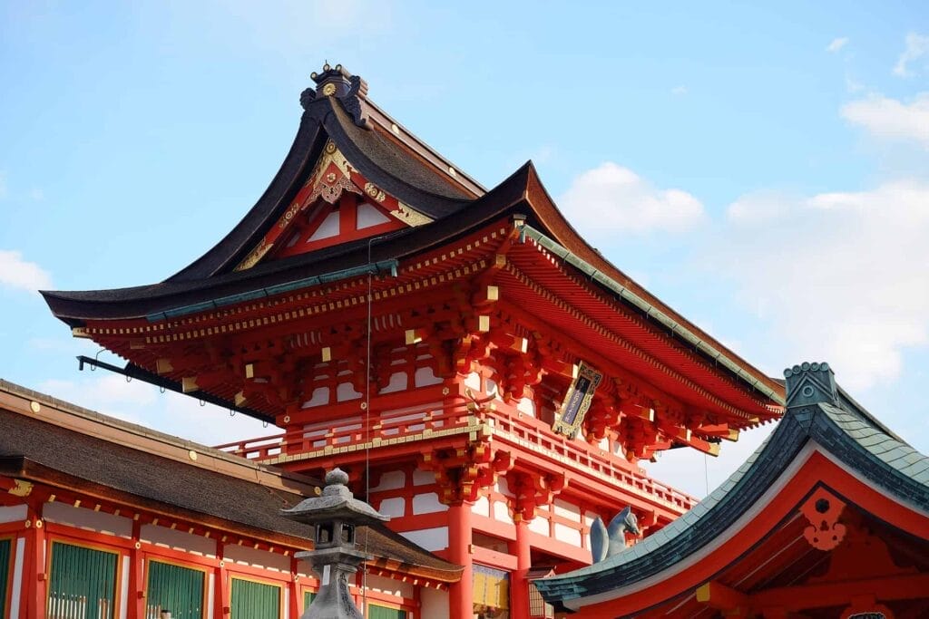 Traditional Japanese temple with red and black architecture against a blue sky, capturing the essence of a perfect weekend in Asia.
